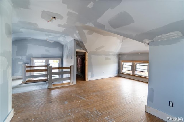 additional living space featuring wood-type flooring and vaulted ceiling