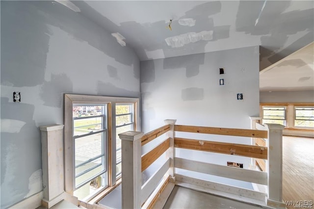 stairway featuring concrete flooring and a healthy amount of sunlight