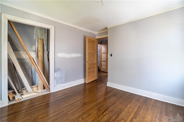 empty room with crown molding and dark hardwood / wood-style flooring