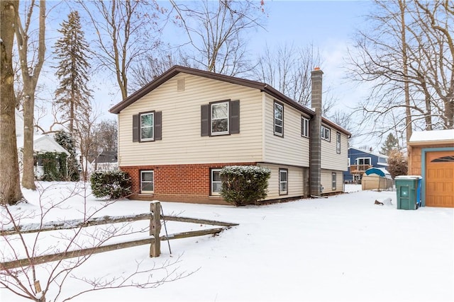 snow covered property with a garage