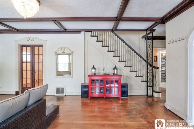 interior space with beamed ceiling, hardwood / wood-style flooring, a textured ceiling, an inviting chandelier, and french doors