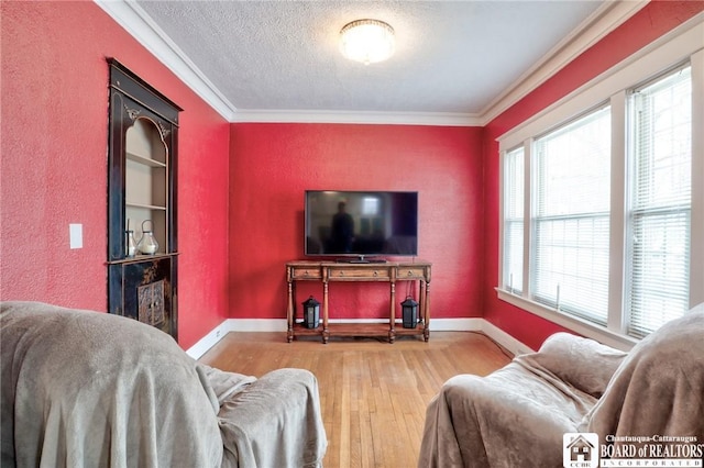 living room with crown molding, wood-type flooring, and a textured ceiling