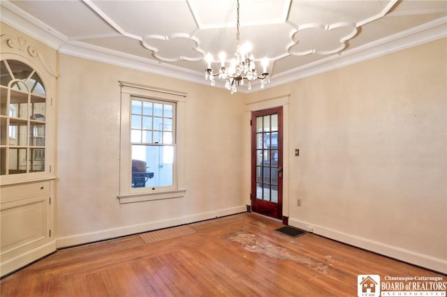 doorway with ornamental molding, a chandelier, and hardwood / wood-style floors