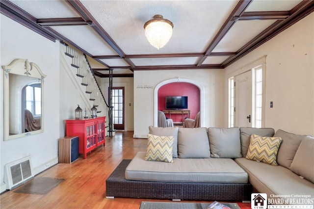 living room featuring wood-type flooring, plenty of natural light, and coffered ceiling