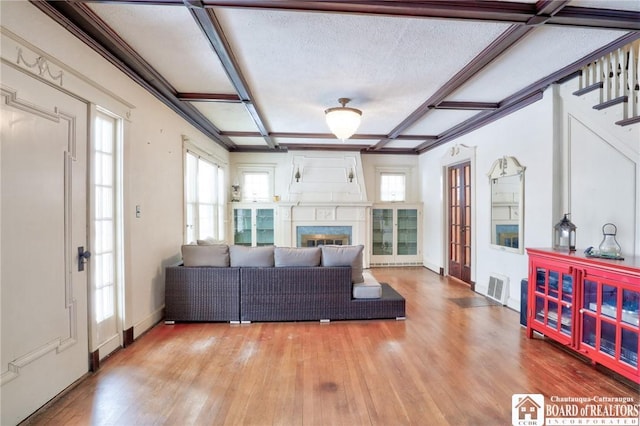 living room featuring hardwood / wood-style flooring, coffered ceiling, and a textured ceiling