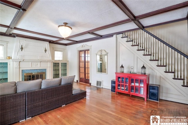 living room with a premium fireplace, coffered ceiling, hardwood / wood-style floors, and a textured ceiling