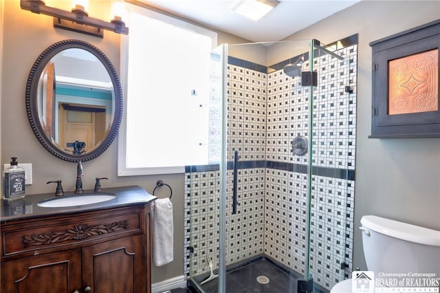 bathroom with vanity, a shower with door, and toilet