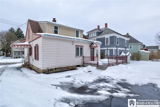 view of snow covered rear of property