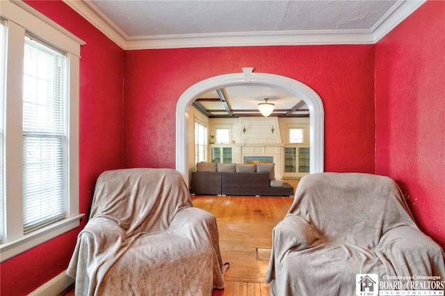 sitting room with wood-type flooring and ornamental molding