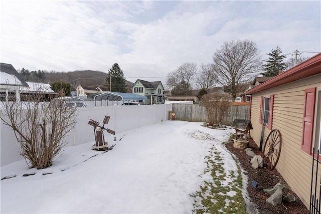 yard covered in snow featuring a carport