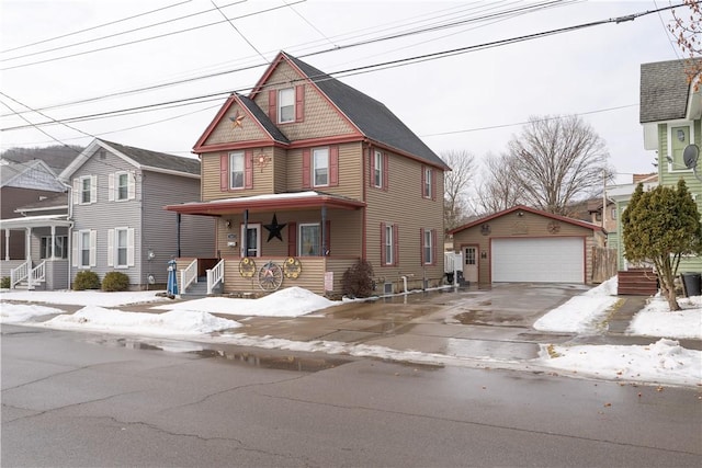 view of front facade featuring a garage, a porch, and an outbuilding