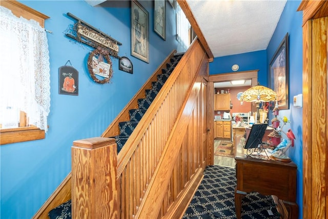 stairs featuring a textured ceiling