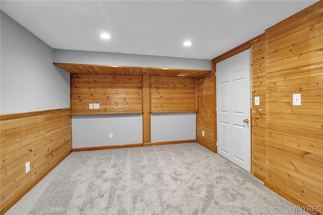 spare room with light carpet and wooden walls