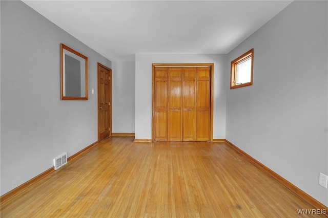 unfurnished bedroom featuring light hardwood / wood-style floors and a closet