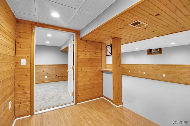 interior space with hardwood / wood-style floors and wood walls