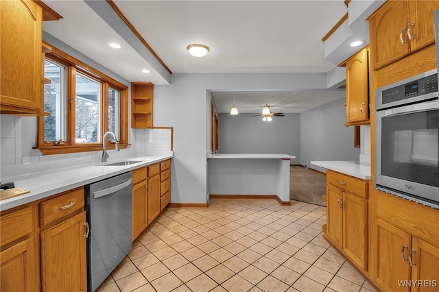 kitchen featuring sink, ceiling fan, appliances with stainless steel finishes, tasteful backsplash, and light tile patterned flooring