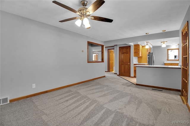 unfurnished living room with light carpet and ceiling fan