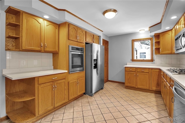 kitchen with light tile patterned flooring, stainless steel appliances, and decorative backsplash