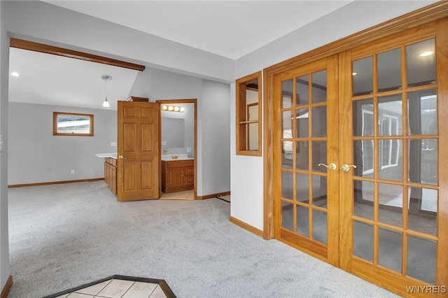 carpeted spare room with french doors and vaulted ceiling