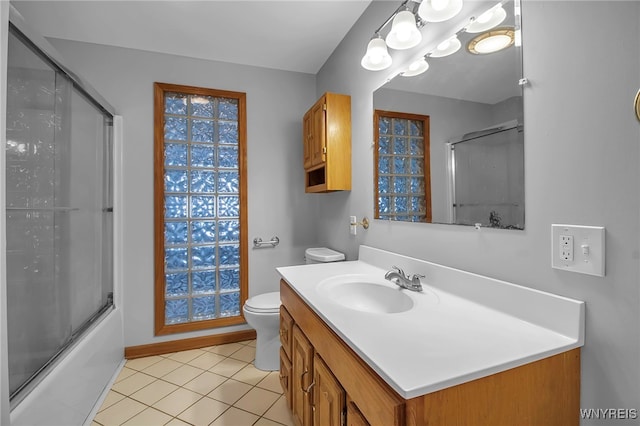 full bathroom with vanity, tile patterned floors, shower / bath combination with glass door, and toilet