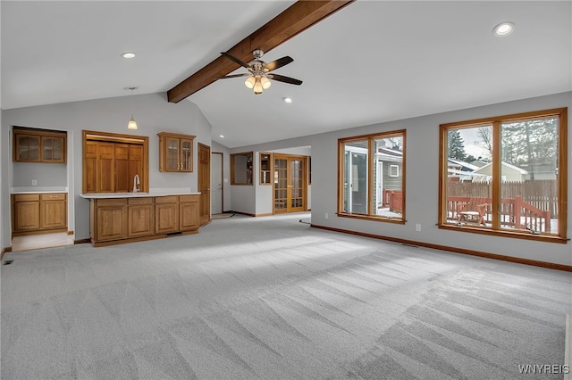 unfurnished living room featuring light carpet, sink, lofted ceiling with beams, and ceiling fan