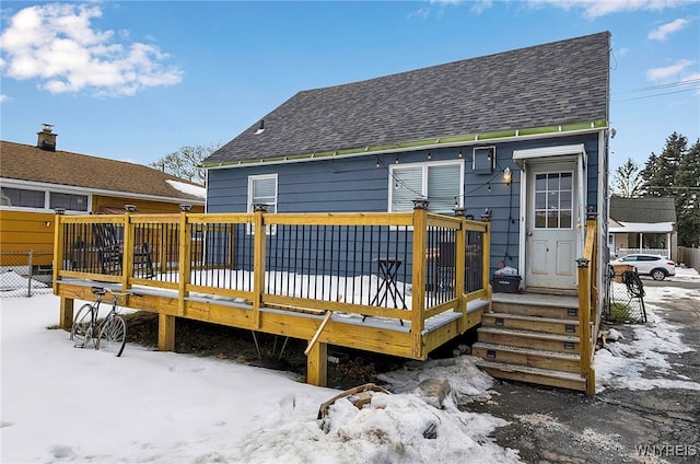 snow covered back of property featuring a wooden deck