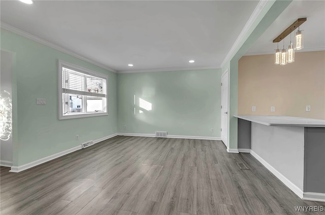 unfurnished living room with hardwood / wood-style flooring and ornamental molding