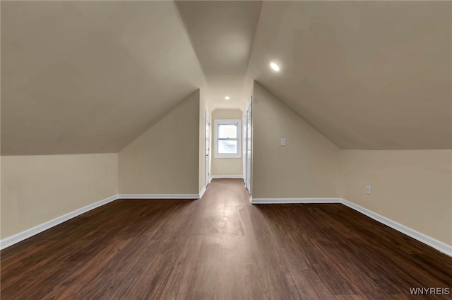 additional living space with vaulted ceiling and dark hardwood / wood-style floors