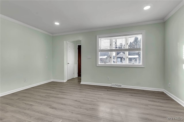 spare room with crown molding and light hardwood / wood-style flooring