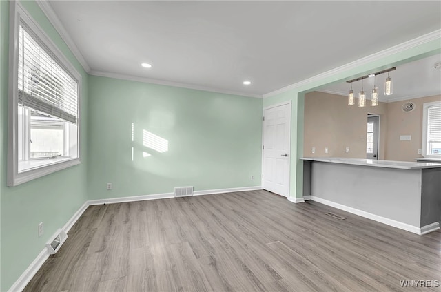 interior space featuring crown molding, plenty of natural light, and hardwood / wood-style flooring