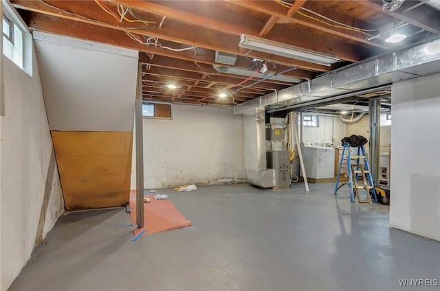 basement featuring washer / clothes dryer, plenty of natural light, and heating unit