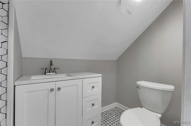 bathroom with vanity, toilet, and vaulted ceiling