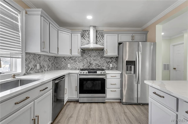 kitchen featuring light stone counters, tasteful backsplash, ornamental molding, stainless steel appliances, and wall chimney range hood