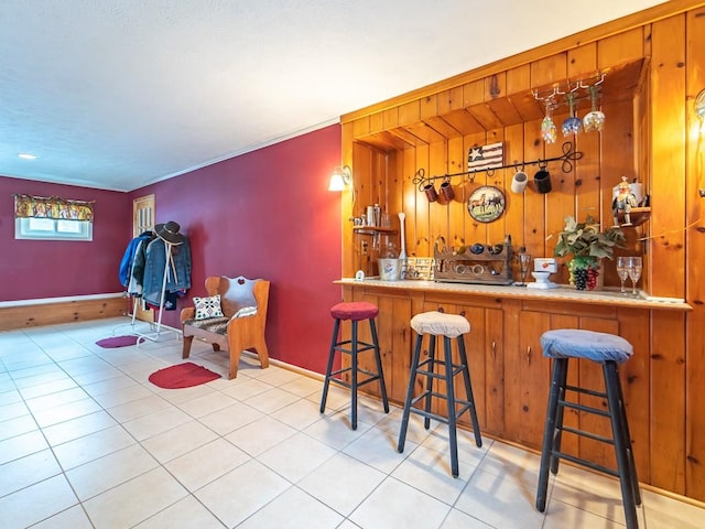 bar with wooden walls and light tile patterned floors