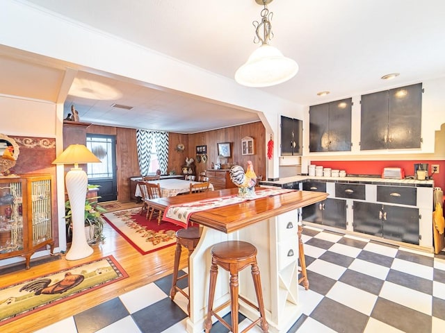 kitchen featuring wooden walls and decorative light fixtures