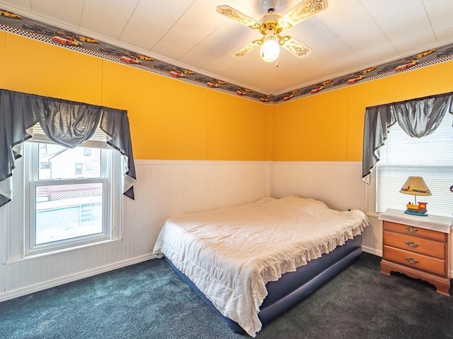 carpeted bedroom with multiple windows, crown molding, and ceiling fan