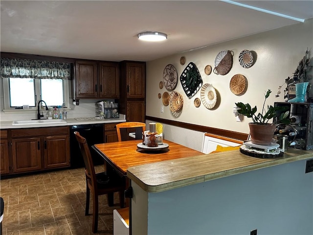 kitchen with sink, dark brown cabinets, and black dishwasher