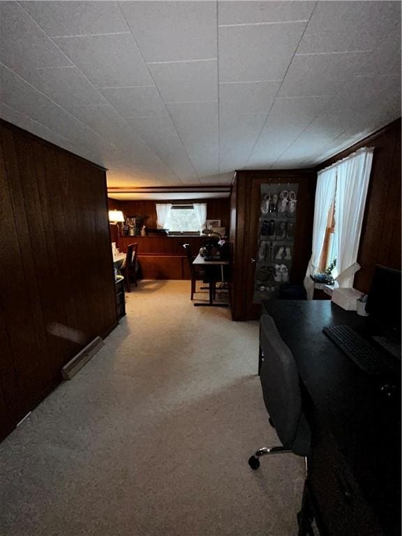 office space with light carpet and wood walls