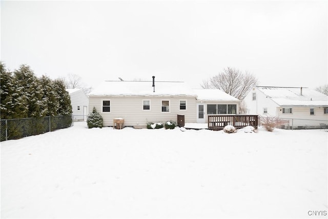 snow covered house featuring a wooden deck