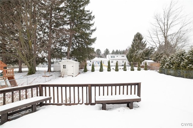 snow covered deck featuring a shed