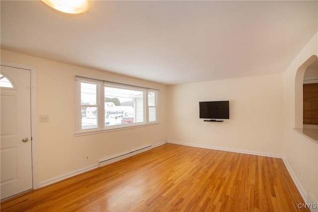 unfurnished living room with baseboard heating and light hardwood / wood-style flooring