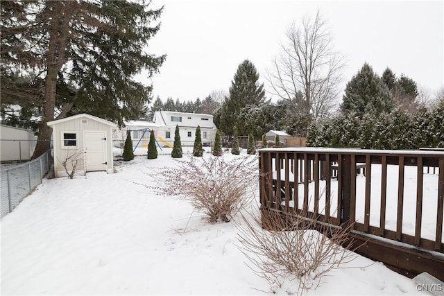 yard covered in snow featuring a shed