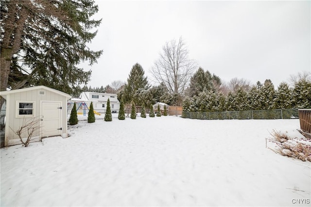 yard layered in snow with a shed