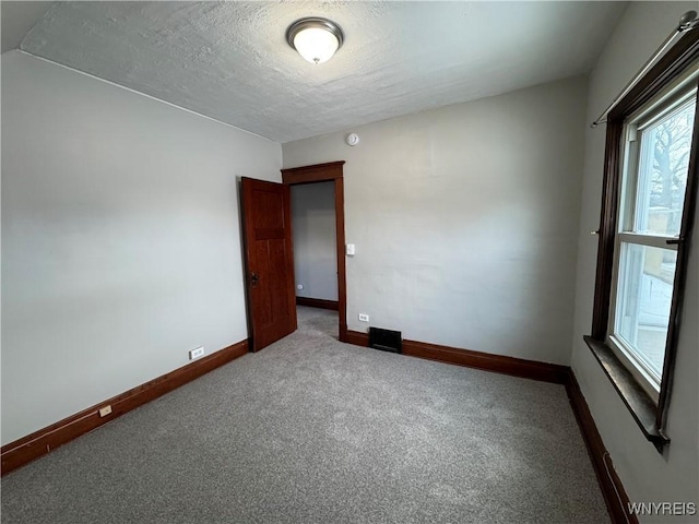 carpeted spare room with a textured ceiling