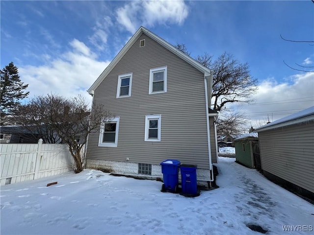 view of snow covered back of property