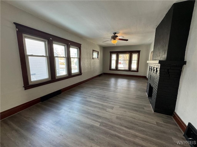 unfurnished living room with hardwood / wood-style flooring, a fireplace, and ceiling fan