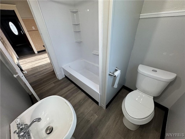 bathroom with walk in shower, toilet, sink, and hardwood / wood-style floors