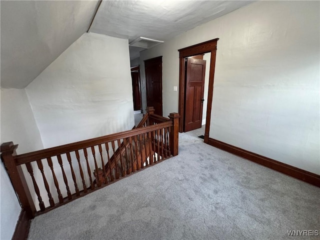 hallway with light carpet and vaulted ceiling