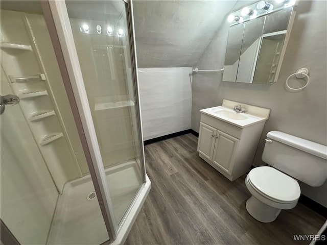 bathroom featuring toilet, vaulted ceiling, vanity, a shower with door, and hardwood / wood-style floors