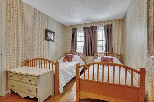 bedroom with light hardwood / wood-style floors and a textured ceiling